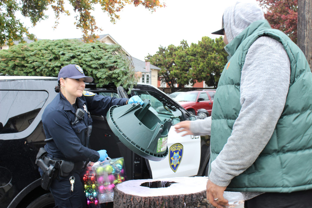 Officer Kristina Tikkanen delivering Christmas trees and gifts